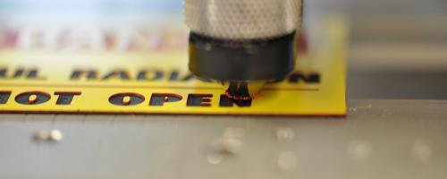 Gravoply™ 3C engraving material being engraved with safety text