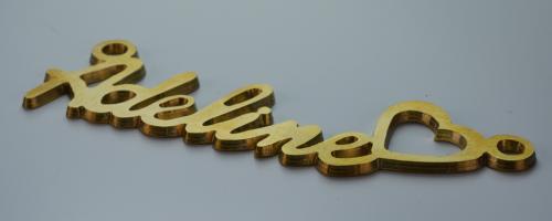 Gold-colored metal cutout reading "Adeline" with a heart shape, made for jewelry customization