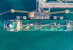 Top-down view of cargo ship being refueled and loaded
